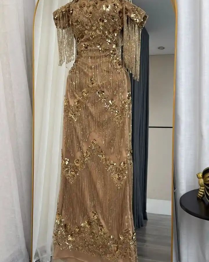 فستان سهرة شك ذهبي مع سلاسل شراريب انسيابية - إطلالة ملكية ساحرة